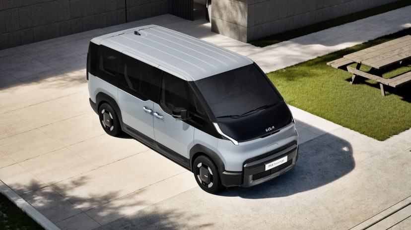 Luftaufnahme der Vorderseite des Kia PV5 Passenger in einer Außenumgebung
